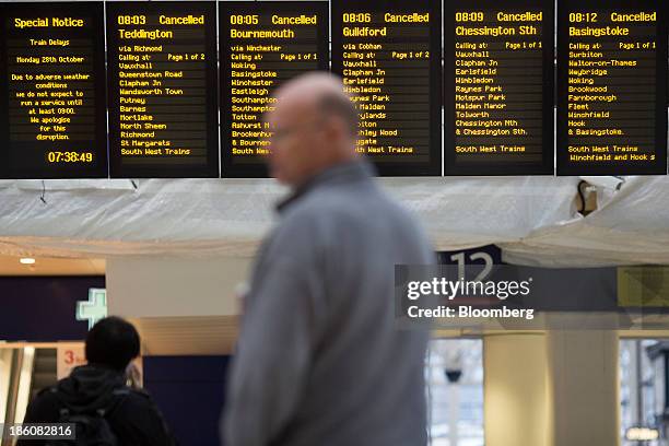 Information boards display cancelled train departures due to adverse weather conditions as commuters wait at Waterloo train station in London, U.K.,...