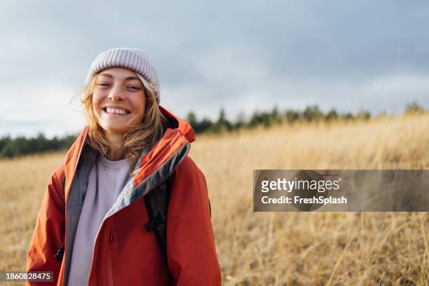 happy woman on a winter hike - orange hat stock pictures, royalty-free photos & images