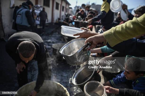 Palestinians receive food and humanitarian aid as Israeli airstrikes continue in Rafah, Gaza on December 19, 2023.
