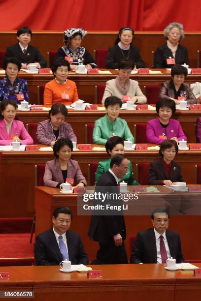 China's Politburo Standing Committee member Wang Qishan walks past President Xi Jinping and Premier Li Keqiang after speaking during the opening...