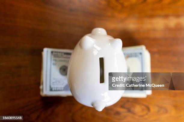 white piggy bank on top of stack of u.s. paper bills - us federal trade commission stock pictures, royalty-free photos & images