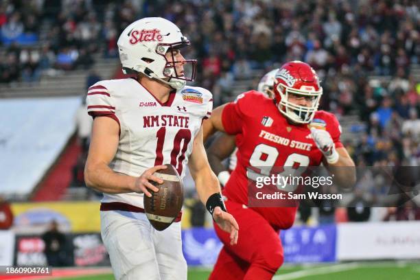 Quarterback Diego Pavia of the New Mexico State Aggies scrambles against defensive lineman Kavika Baumgartner of the Fresno State Bulldogs during the...