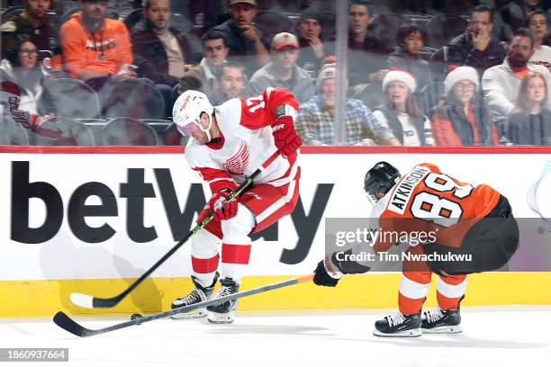 Daniel Sprong of the Detroit Red Wings and Cam Atkinson of the Philadelphia Flyers challenge for the puck during the first period at the Wells Fargo...