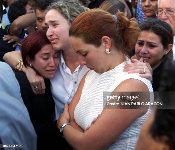 The daughter of the ex president Arnoldo Aleman, Maria Dolores Aleman, is hugged by her younger sister, Mari Alejandra Aleman, during the burial of...