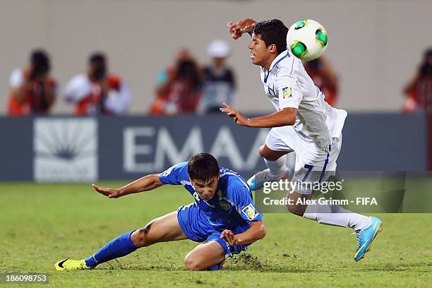 Brayan Velasquez of Honduras is challenged by Akramjon Komilov of Uzbekistan during the FIFA U-17 World Cup UAE 2013 Round of 16 match between...