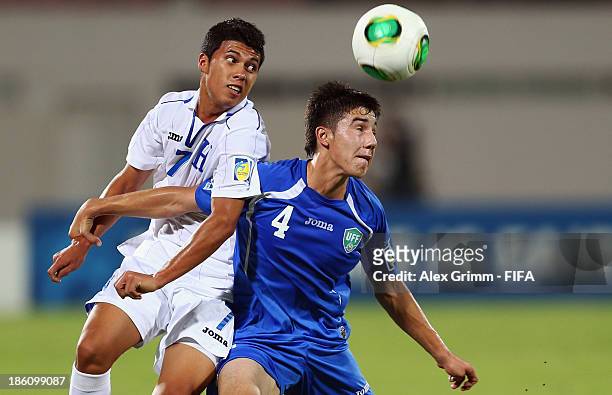 Brayan Velasquez of Honduras is challenged by Akramjon Komilov of Uzbekistan during the FIFA U-17 World Cup UAE 2013 Round of 16 match between...