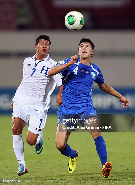 Brayan Velasquez of Honduras is challenged by Akramjon Komilov of Uzbekistan during the FIFA U-17 World Cup UAE 2013 Round of 16 match between...