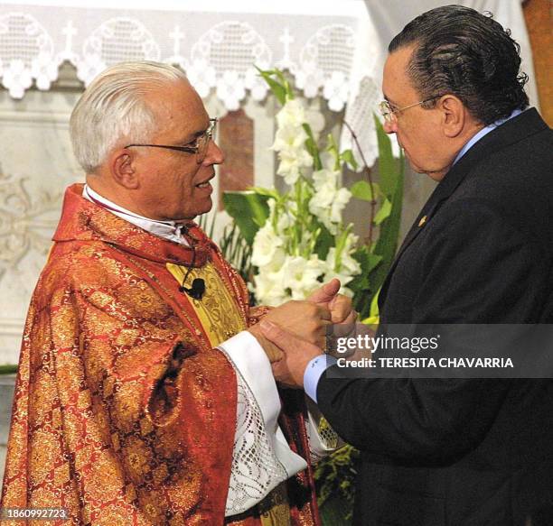 Costa Rican priest Hugo Barrantes , new archbishop of the Catholic Church greets President Abel Pacheco 18 October 2002, during the inauguration of...