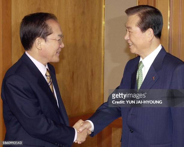 South Korean President Kim Dae-jung, right, shakes hands with Lee Hoi-chang, presidential candidate of the main opposition Grand National Party,...