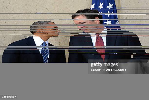 President Barack Obama talks with new Federal Bureau of Investigation director James Comey during his installation ceremony at the FBI headquarters...