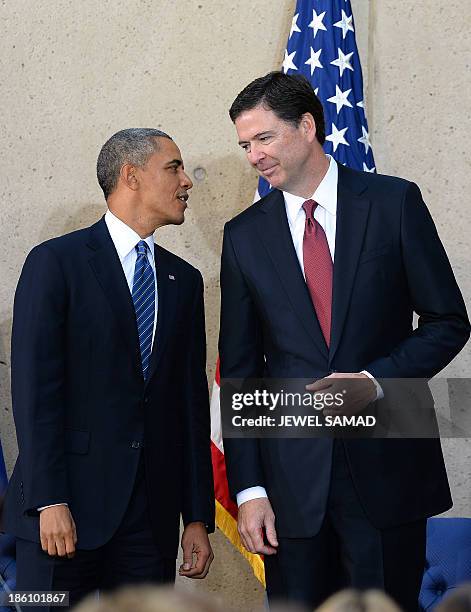 President Barack Obama talks with new Federal Bureau of Investigation director James Comey during his installation ceremony at the FBI headquarters...