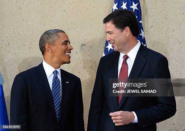 President Barack Obama talks with new Federal Bureau of Investigation director James Comey during his installation ceremony at the FBI headquarters...