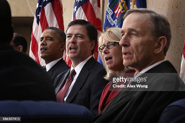 President Barack Obama, FBI Director James Comey, his wife Patrice, Judge John Walker listen to the song God Bless America during a ceremonial...