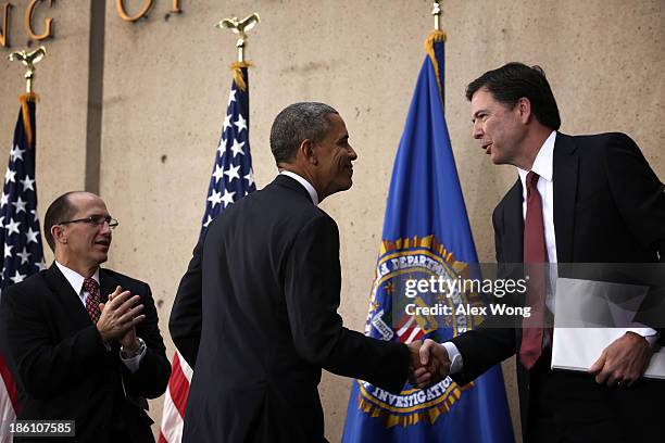 Director James Comey shakes hands with U.S. President Barack Obama as Deputy FBI Director Sean Joyce looks on during a ceremonial swearing-in...