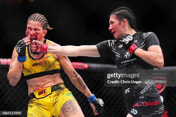 Irene Aldana of Mexico punches Karol Rosa of Brazil in a bantamweight fight during the UFC 296 event at T-Mobile Arena on December 16, 2023 in Las...