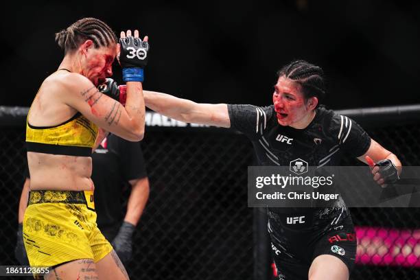 Irene Aldana of Mexico punches Karol Rosa of Brazil in a bantamweight fight during the UFC 296 event at T-Mobile Arena on December 16, 2023 in Las...