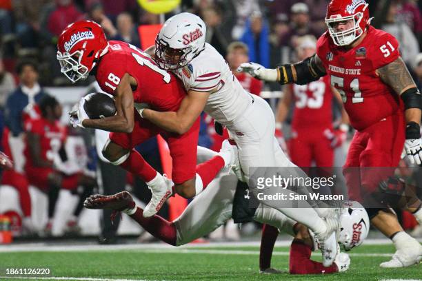 Inside linebacker Sone Aupiu of the New Mexico State Aggies tackles wide receiver Jalen Moss of the Fresno State Bulldogs during the second half of...
