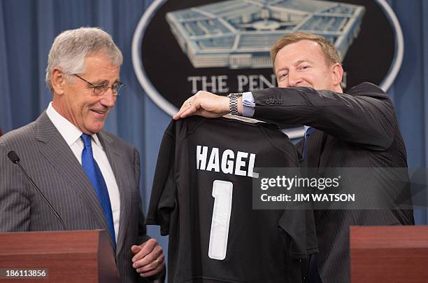 Defense Secretary Chuck Hagel receives a New Zealand All Blacks rugby jersey from New Zealand Defense Minister Jonathan Coleman during a press...