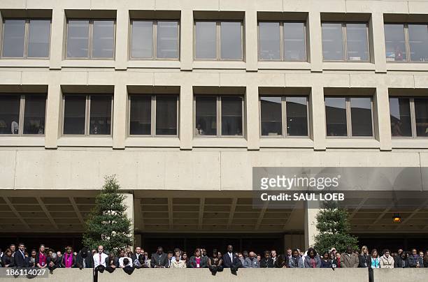 Employees listen as US President Barack Obama speaks during the installation ceremony for FBI Director James Comey at Federal Bureau of Investigation...