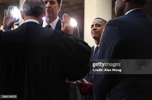 Director James Comey participates in a ceremonial swearing-in, officiated by Judge John Walker , as U.S. President Barack Obama looks on at the FBI...