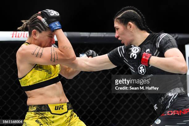 Irene Aldana of Mexico punches Karol Rosa of Brazil in a bantamweight fight during the UFC 296: Edwards vs. Covington event at T-Mobile Arena on...