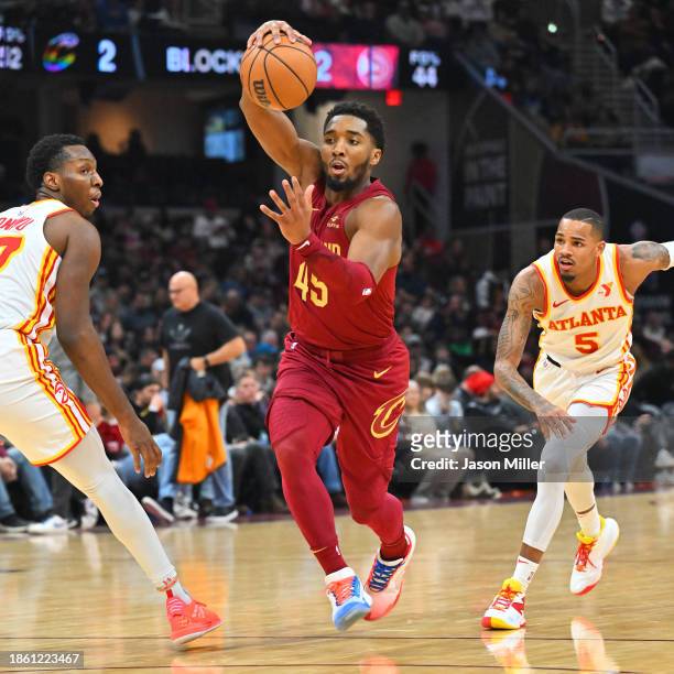 Donovan Mitchell of the Cleveland Cavaliers goes to the basket between Onyeka Okongwu Dejounte Murray of the Atlanta Hawks during the fourth quarter...