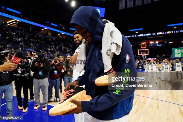 Anthony Edwards of the Minnesota Timberwolves holds his signature Adidas sneaker after the game against the Indiana Pacers at Target Center on...