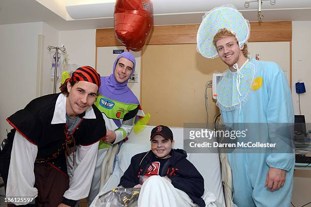 Matt Bartkowski, Reilly Smith, and Dougie Hamilton of the Boston Bruins celebrate Halloween with Brendan at Boston Children's Hospital on October 28,...
