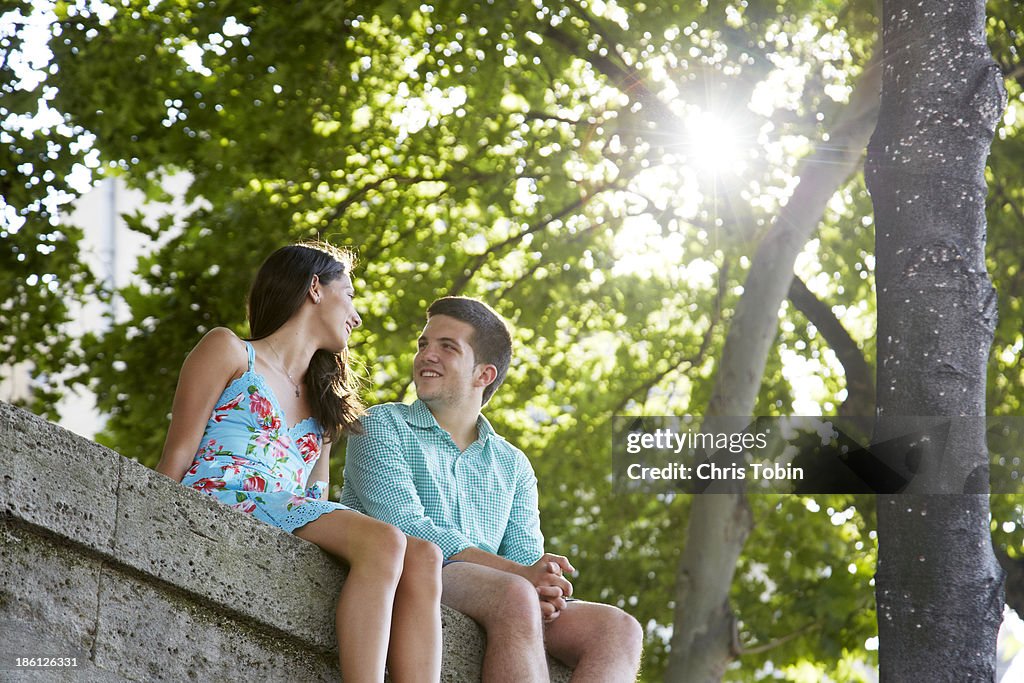 Young couple sitting on a wall