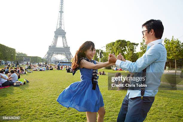 young couple dancing at the eiffel tower - korean people stock pictures, royalty-free photos & images