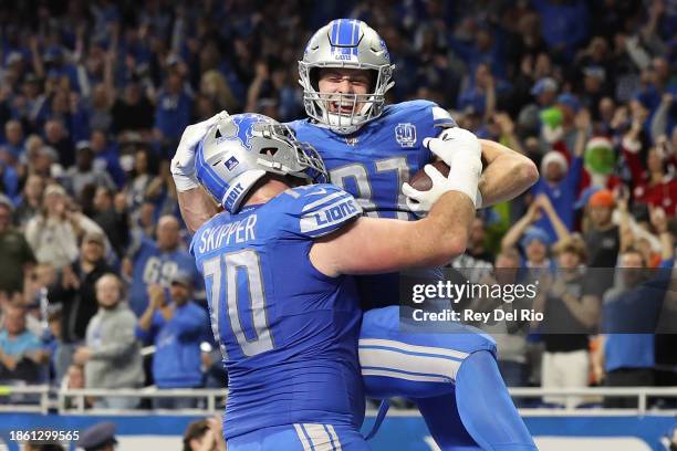Sam LaPorta of the Detroit Lions celebrates his touchdown catch with Dan Skipper during the fourth quarter against the Denver Broncos at Ford Field...