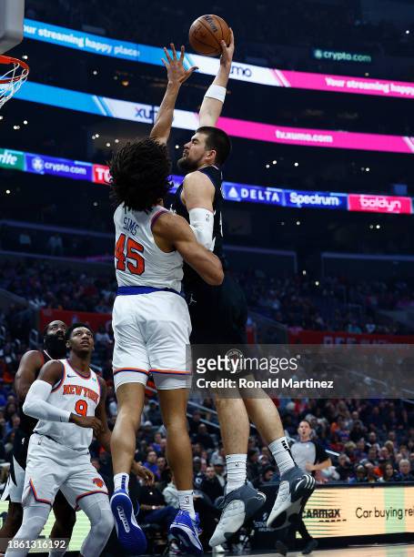 Ivica Zubac of the LA Clippers takes a shot against Jericho Sims of the New York Knicks in the first half at Crypto.com Arena on December 16, 2023 in...