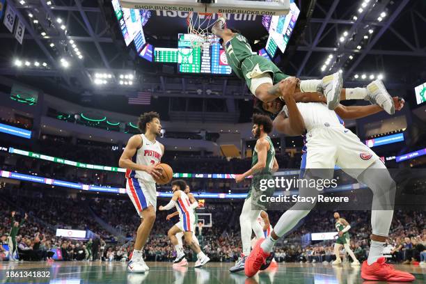 MarJon Beauchamp of the Milwaukee Bucks dunks over James Wiseman of the Detroit Pistons during the first half of a game at Fiserv Forum on December...