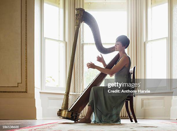 young woman playing harp - harpe photos et images de collection