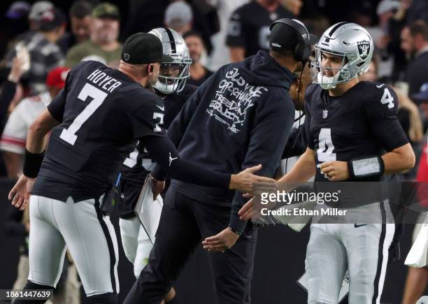 Quarterback Brian Hoyer and quarterback Aidan O'Connell of the Las Vegas Raiders slap hands after against O'Connell threw a touchdown to tight end...