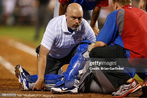 Assistant athletic trainer Ed Halbur of the Chicago Cubs attends to Dioner Navarro during the game against the Philadelphia Phillies at Citizens Bank...