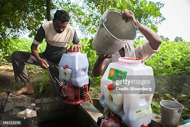 Worker adds water from a well to the tank of crop spraying equipment on the farm of Jarnail Singh in Jajjal village, Punjab, India, on Wednesday,...