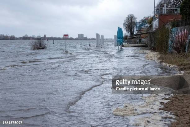 December 2023, Hamburg: The water of the Elbe washes over parts of the beach in Hamburg-Övelgönne at high tide. The Federal Maritime and Hydrographic...