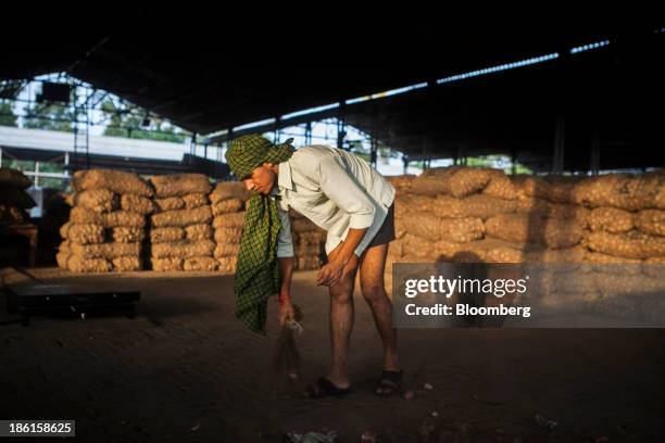 Worker sweeps the ground at an onion wholesale market in Bhatinda, Punjab, India, on Wednesday, Aug. 28, 2013. The Green Revolution introduced...