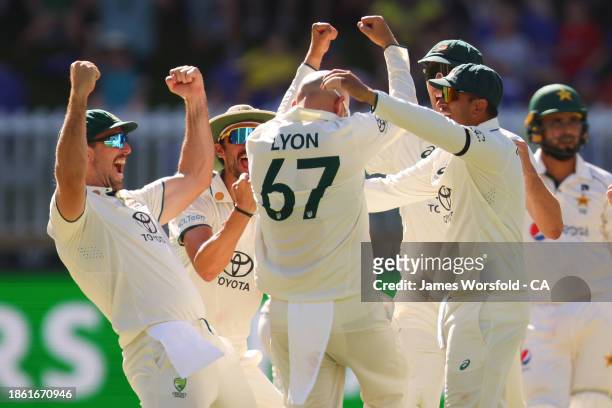 Nathan Lyon of Australia and all of the team celebrate Nathan Lyon 500th Test Wicket during day four of the Men's First Test match between Australia...