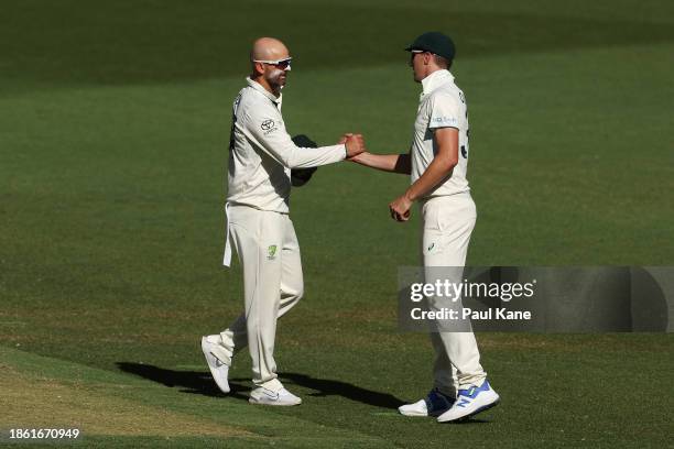 Nathan Lyon of Australia celebrates with Australian captain Pat Cummins after dismissing Faheem Ashraf of Pakistan following a DRS review and taking...