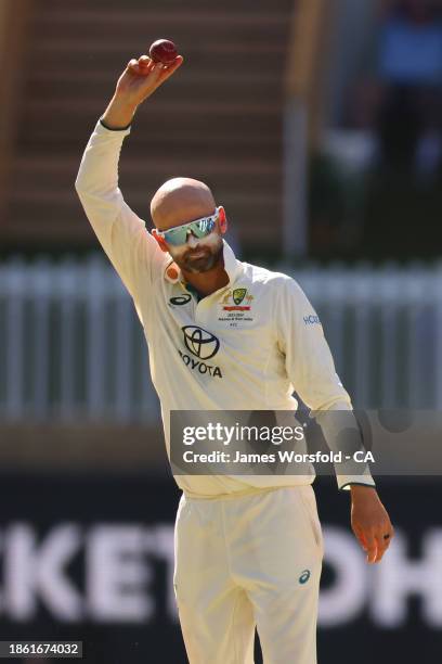 Nathan Lyon of Australia raises the ball to the crowd during day four of the Men's First Test match between Australia and Pakistan at Optus Stadium...