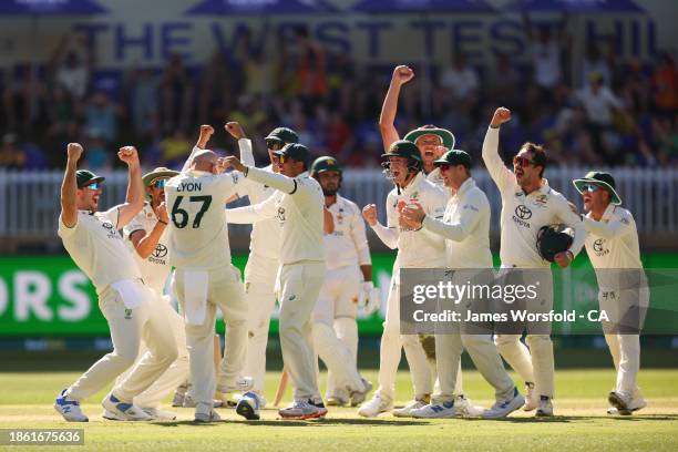 Nathan Lyon of Australia and all of the team celebrate Nathan Lyon 500th Test Wicket during day four of the Men's First Test match between Australia...