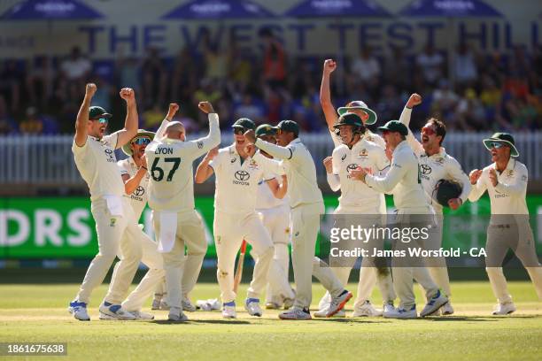 Nathan Lyon of Australia and all of the team celebrate Nathan Lyon 500th Test Wicket during day four of the Men's First Test match between Australia...