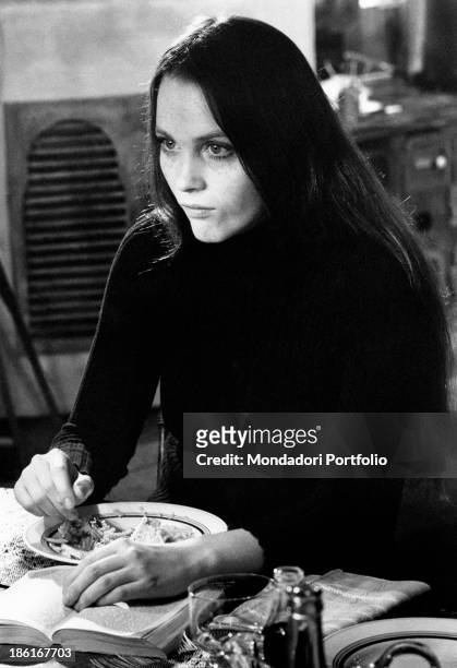American actress Tisa Farrow, sister of American actress Mia Farrow , eating reading a book in the film And Hope to Die. Paris, 1972.