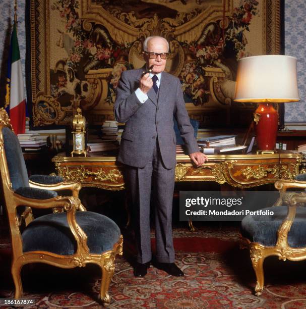 The President of the Italian Republic Sandro Pertini posing leaned on the desk of his office at Quirinale with the pipe in the hands. Rome, 1983.