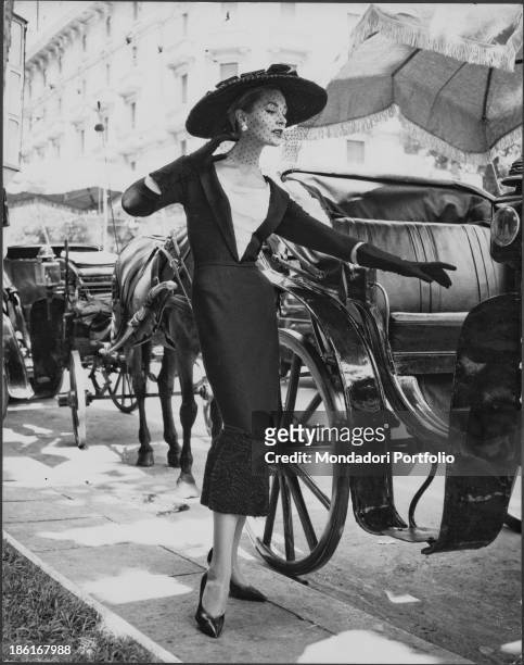 Model wearing a dress with three quarter length gloves and a hat-veil from Fontana sisters' fashion collection. Rome, 1950s.