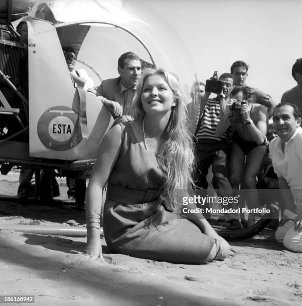 French actress and writer Marina Vlady posing for the photographers at the beach. Behind her, a helicopter. Venice, August 1959.