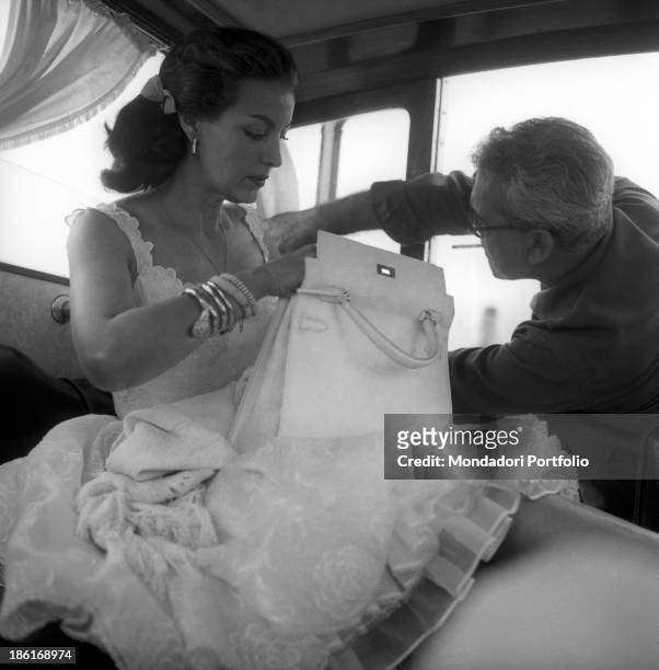 Mexican actress Maria Félix wearing a chiffon skirt and checking her bag on a boat. She's taking part in the Venice Film Festival. Venice, August...