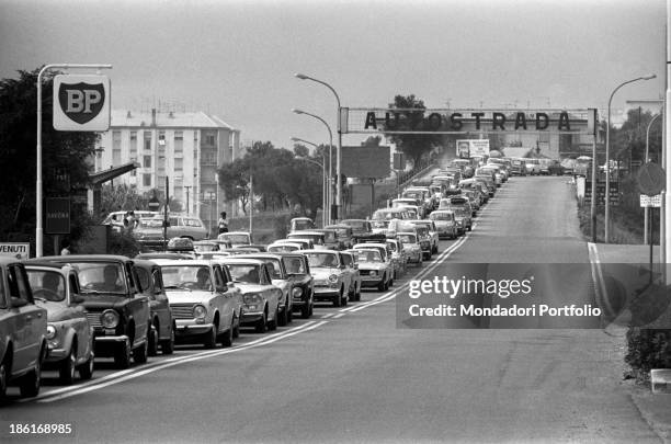 Cars waiting in a queue on the Autostrada dei Fiori . On the roadside, a British Petroleum sign. Savona, 15th August 1969.
